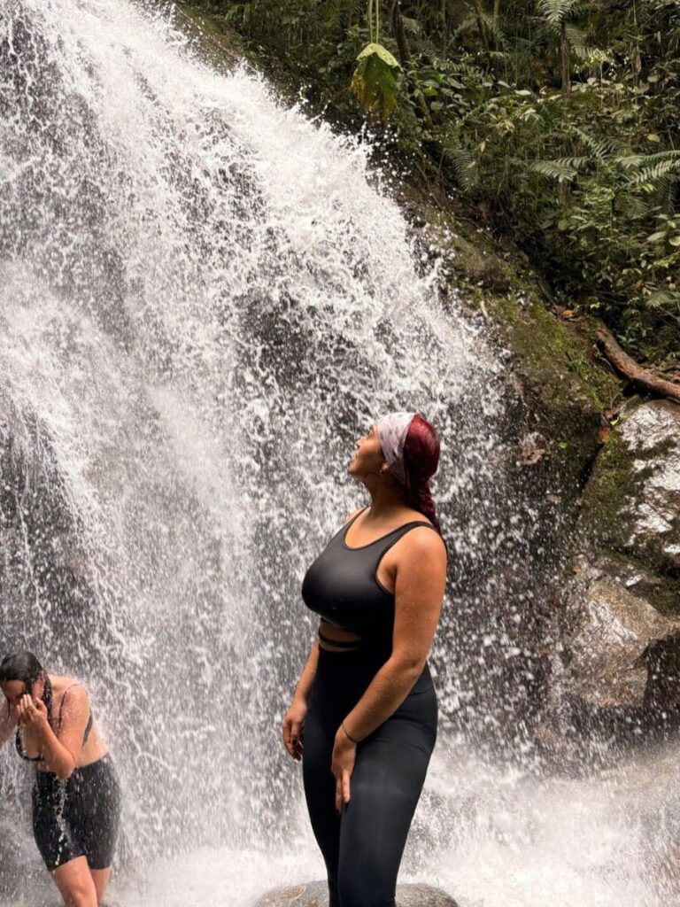 Persona observando una cascada en el camino a las Cuevas del Higuerón en Envigado.