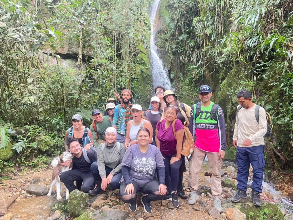 Foto grupal de senderistas frente a una cascada.